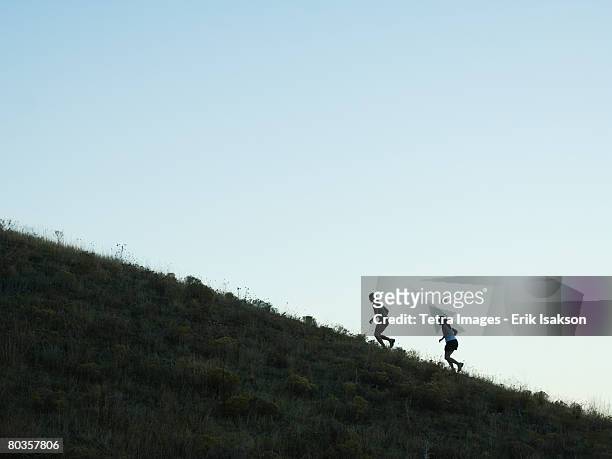 people running up mountain, salt flats, utah, united states - steil stock-fotos und bilder