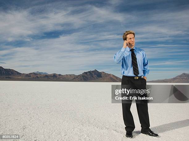 businessman talking on cell phone, salt flats, utah, united states - glaring meaning stock pictures, royalty-free photos & images