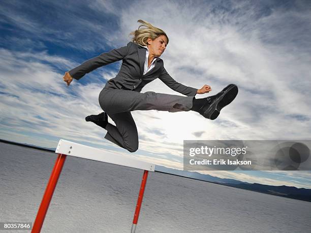 businesswoman jumping over hurdle, salt flats, utah, united states - hurdling track event fotografías e imágenes de stock