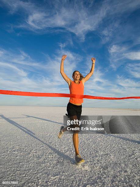 woman running across finish line, utah, united states - finish line ribbon stock pictures, royalty-free photos & images