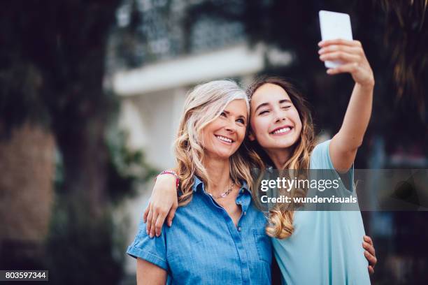 beautiful mature mother and adult daughter taking selfies together - grandma daughter stock pictures, royalty-free photos & images