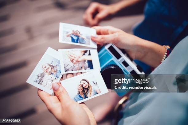young woman holding polaroid photos with mum on summer holidays - fotografia imagem imagens e fotografias de stock