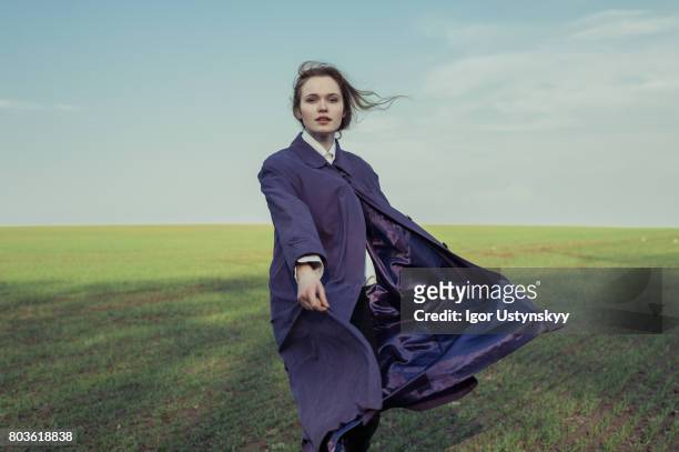 portrait of woman in the field in coat - fashion magazine cover stock-fotos und bilder
