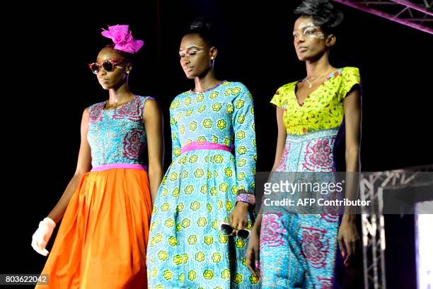 Models display creations on June 29, 2017 in Niari Taly, a popular neighborhood in the Senegalese capital during Dakar Fashion Week, where the...
