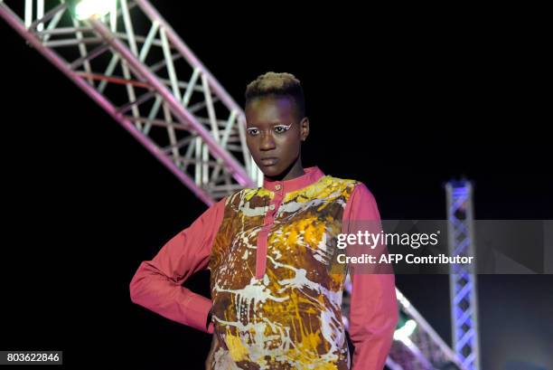 Models display creations on June 29, 2017 in Niari Taly, a popular neighborhood in the Senegalese capital during Dakar Fashion Week, where the...