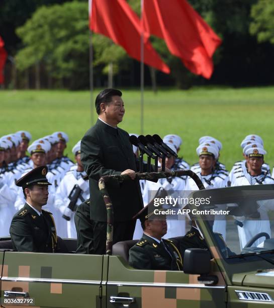 Chinese President Xi Jinping begins a review of troops from a car during a military parade in Hong Kong on June 30, 2017. Xi tours a garrison of Hong...