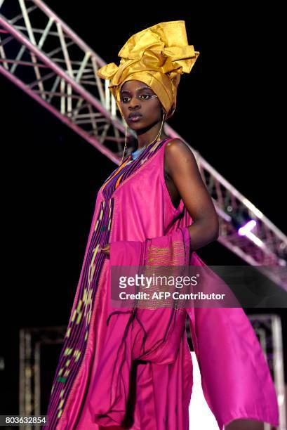 Model presents a creation during Dakar Fashion Week on June 29, 2017 in Niari Taly, a popular neighborhood in the Senegalese capital, where the...