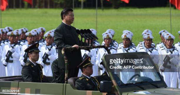 Chinese President Xi Jinping begins a review of troops from a car during a military parade in Hong Kong on June 30, 2017. Xi tours a garrison of Hong...