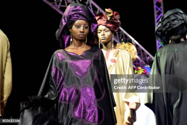 Models present creations during Dakar Fashion Week on June 29, 2017 in Niari Taly, a popular neighborhood in the Senegalese capital, where the...