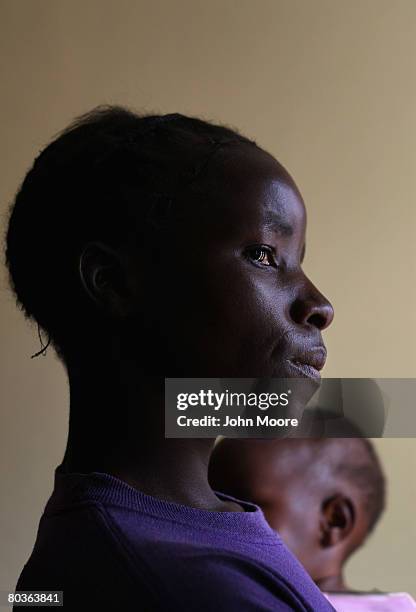 Young woman who was raped, became HIV positive and pregnant, holds her year-old daughter March 21, 2008 in Bulawayo, Zimbabwe. She had tried to abort...