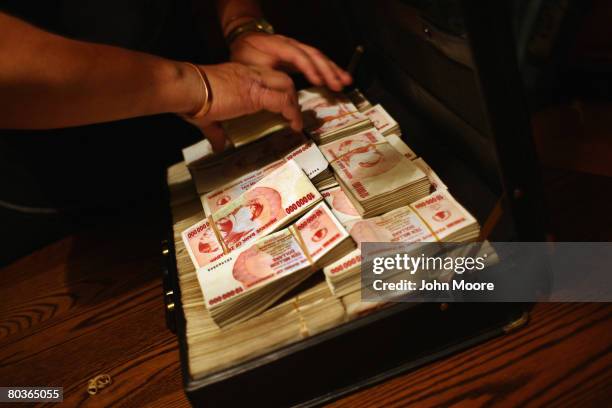 Church aid organizer packs $65 billion Zimbabwean dollars into a briefcase March 21, 2008 in Bulawayo, Zimbabwe. He had received the foreign currency...