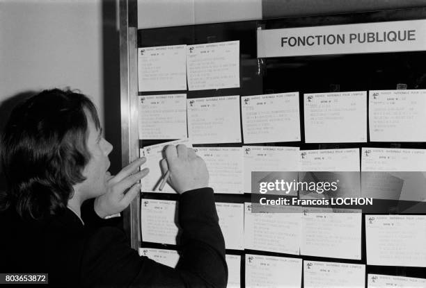 Chômeur recherchant un emploi sur le tableau d'un bureau de l'ANPE à Paris, France, le 21 octobre 1975.