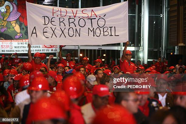 Petroleos de Venezuela workers lift a banner in the Simon Bolivar hall before a meeting with Venezuelan Oil Minister Rafael Ramirez and President...