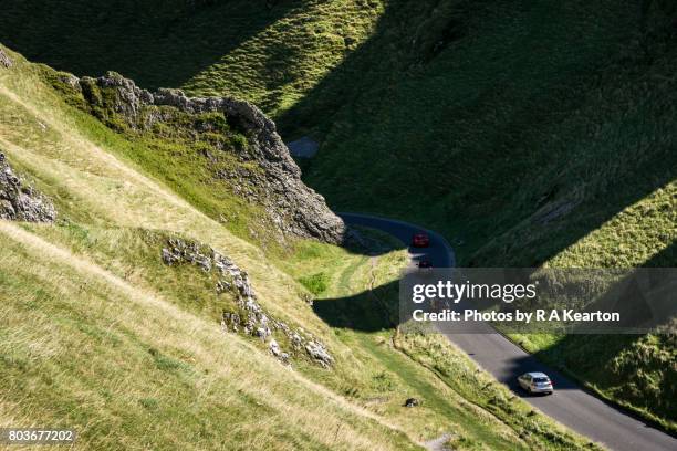 cars driving down winnats pass, peak district, derbyshire - steil stockfoto's en -beelden