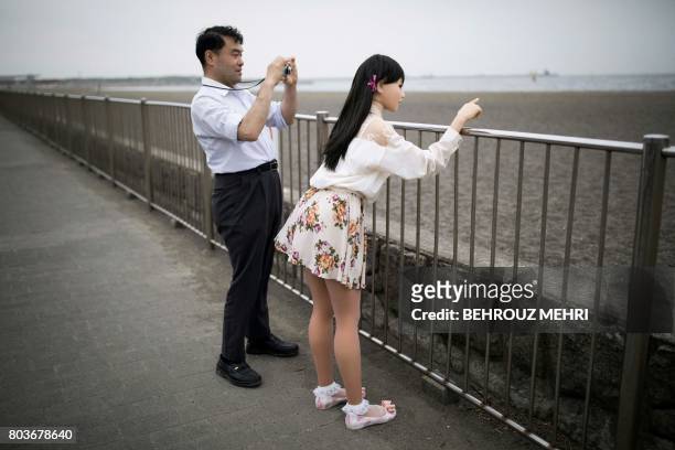 In this picture taken on May 9 physiotherapist Masayuki Ozaki takes pictures of his silicone sex doll Mayu in Tokyo Bay. Around 2,000 of the...