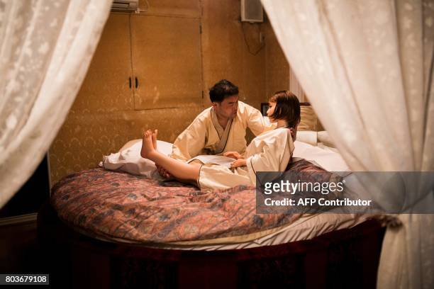 In this picture taken late on June 13 physiotherapist Masayuki Ozaki puts his silicone sex doll Mayu to bed at a love hotel in Yachimata, Chiba...