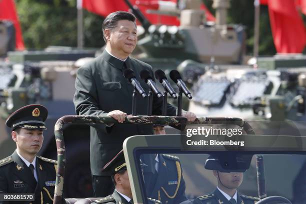 Xi Jinping, China's president, rides in a vehicle as he reviews People's Liberation Army troops at the Shek Kong Barracks in Hong Kong, China, on...