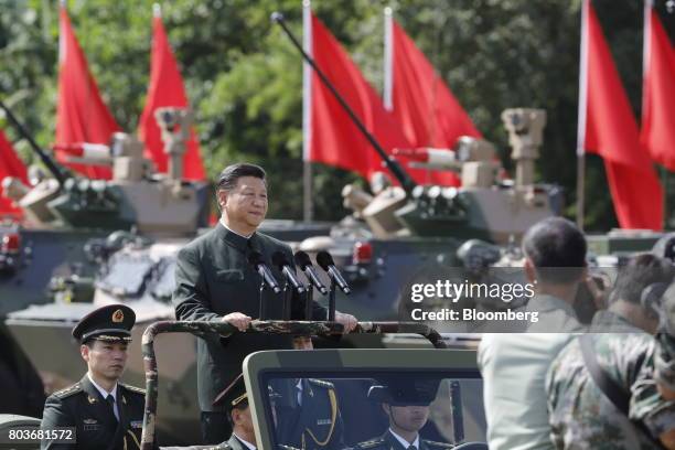 Xi Jinping, China's president, rides in a vehicle as he reviews People's Liberation Army troops at the Shek Kong Barracks in Hong Kong, China, on...