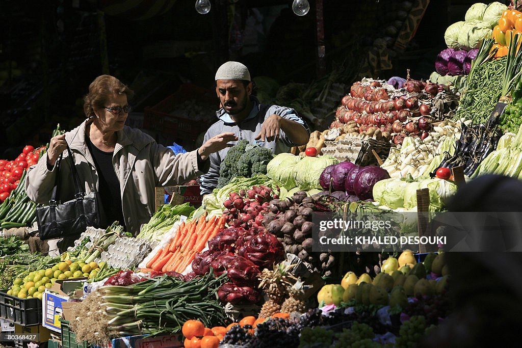 An Egyptian woman buys vegetables at a m