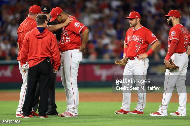 Manager Mike Scioscia talks with JC Ramirez as Cliff Pennington and Danny Espinosa of the Los Angeles Angels of Anaheim look on during the sixth...