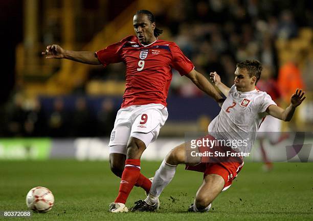 Cameron Jerome of England beats Adam Kokoszka of Poland to the ball during the Under-21 International Friendly between England and Poland at Molineux...