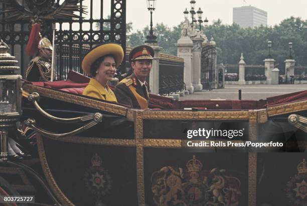 Jean, Grand Duke of Luxembourg rides with Queen Elizabeth II in an open carriage through the gates of Buckingham Palace, at the start of a four-day...