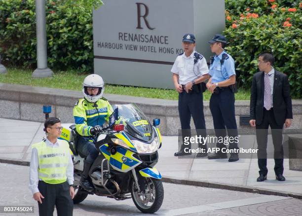This photo taken on June 29, 2017 shows members of the Hong Kong police outside the Renaissance Hotel in the Wanchai district of Hong Kong as...