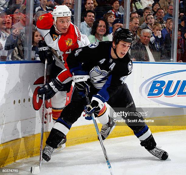 Vincent Lecavalier of the Tampa Bay Lightning checks Jay Bouwmeester of the Florida Panthers into the boards while chasing the puck during the first...