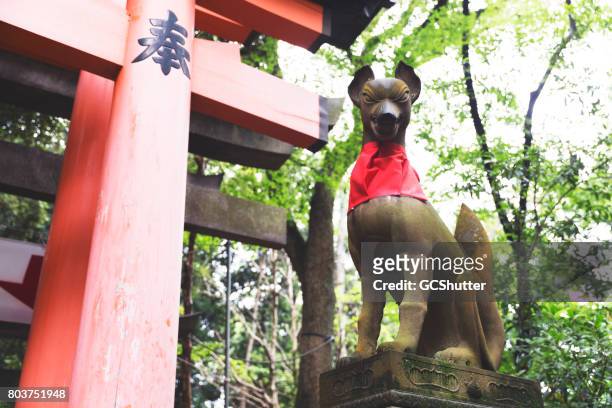 fox statue hissing at the crowd visiting the fushimi inari-taisha shrine - inari shrine stock pictures, royalty-free photos & images
