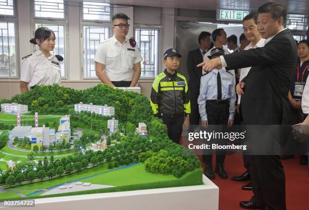 Xi Jinping, China's president, right, and Leung Chun-ying, Hong Kong's outgoing chief executive, second right, inspect a model of the Hong Kong...