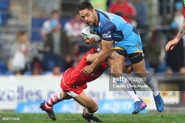 Jarryd Hayne of the Titans is tackled during the round 17 NRL match between the Gold Coast Titans and the St George Illawarra Dragons at Cbus Super...