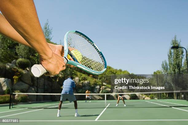 tennis player serving tennis ball - doubles tennis stock-fotos und bilder