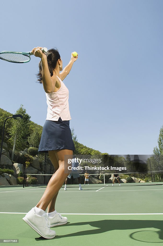 Tennis player serving ball