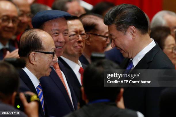 China's President Xi Jinping is greeted by Hong Kong tycoons Li Ka-shing and Lui Che-woo before a photo session during Xi's visit to Hong Kong on...