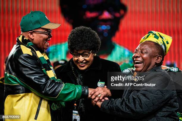 Former wife of the late South African President Nelson Mandela, Winnie Mandela holds the hands of South African President Jacob Zuma and South...