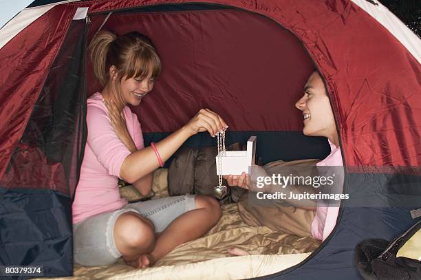 teen couple with heart-shaped locket - heart locket stock-fotos und bilder