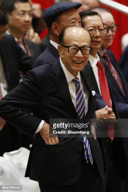 Billionaire Li Ka-shing, chairman of CK Hutchison Holdings Ltd. And Cheung Kong Property Holdings Ltd., reacts during a photo session at a meeting...
