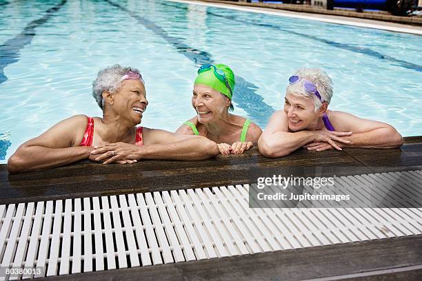 smiling senior women in pool - active seniors group stock pictures, royalty-free photos & images