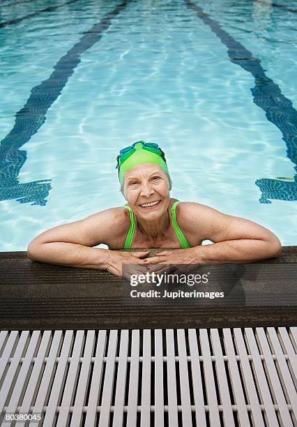 senior woman in swimming pool - cuffia da nuoto foto e immagini stock