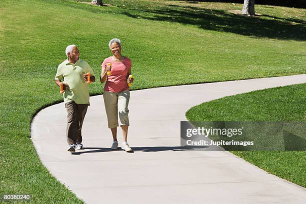 senior couple walking - concrete footpath stock pictures, royalty-free photos & images