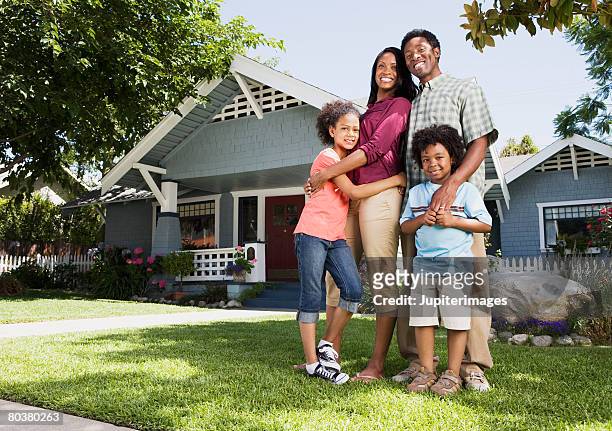 embracing family in front of home - suburban family stock pictures, royalty-free photos & images