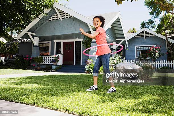 girl with plastic ring toy on front lawn of house - hooping stock pictures, royalty-free photos & images