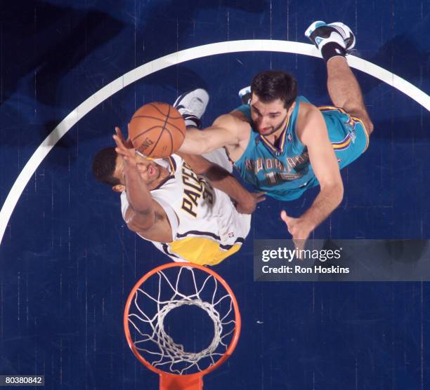 Peja Stojakovic of the New Orleans Hornets scores over Danny Granger of the Indiana Pacers at Conseco Fieldhouse on March 25, 2008 in Indianapolis,...