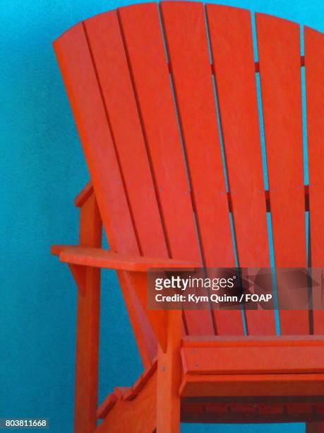 orange adirondack chair against wall - adirondack chair closeup stock pictures, royalty-free photos & images