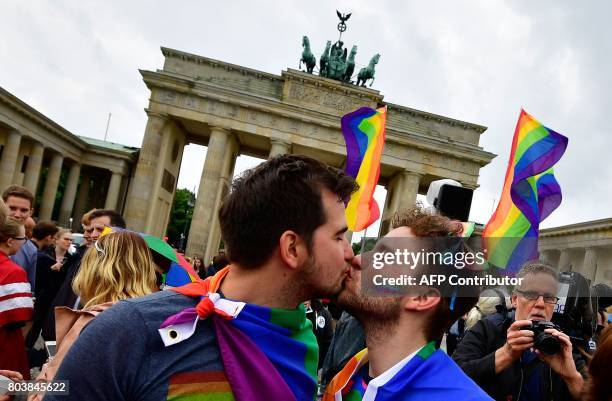 Two men kiss as they attend a rally of gays and lesbians in front of the Brandenburg Gate in Berlin on June 30, 2017. The German parliament legalised...