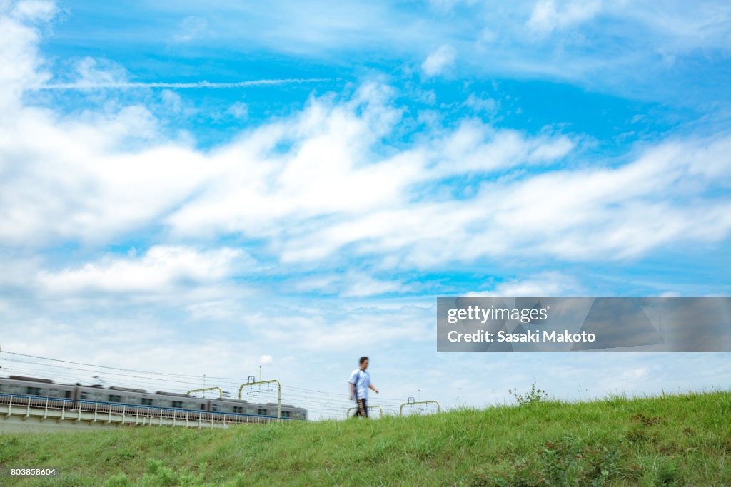 People and trains passing by during daytime in summer