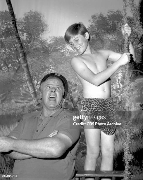 Promotional portrait of American actor Alan Hale Jr. With child actor Kurt Russell, who holds a 'vine' and stands on a step-stool in front of a...