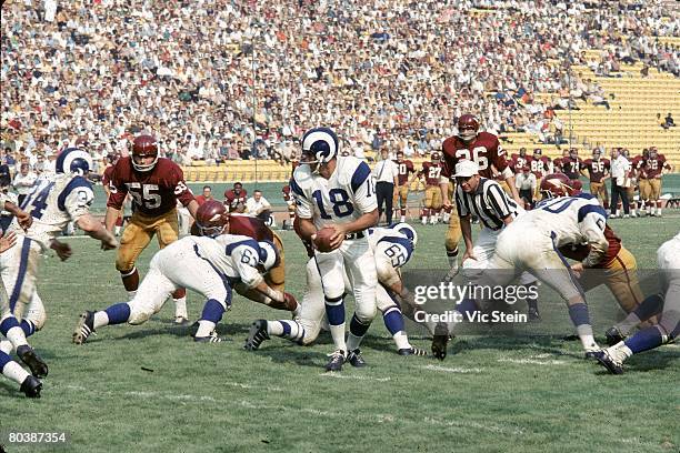 Quarterback Roman Gabriel of the the Los Angeles Rams turns to handoff during an NFL game against the Washington Redskins at the Los Angeles Memorial...