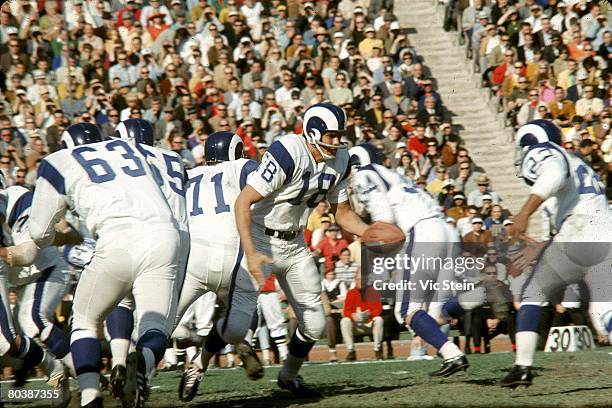 Quarterback Roman Gabriel of the Los Angeles Rams turns to handoff during an NFL game against the Green Bay Packers at the Los Angeles Memorial...