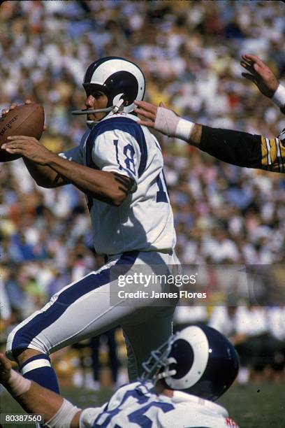 Quarterback Roman Gabriel of the Los Angeles Rams eludes the pass rush in an NFL game against the Green Bay Packers at the Los Angeles Memorial...